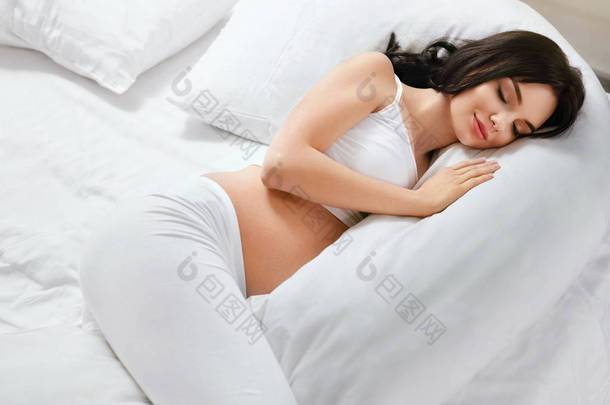 孕妇<strong>枕</strong>头</strong>。女孩睡在身体<strong>枕</strong>头</strong>上的白色床室内。高分辨率