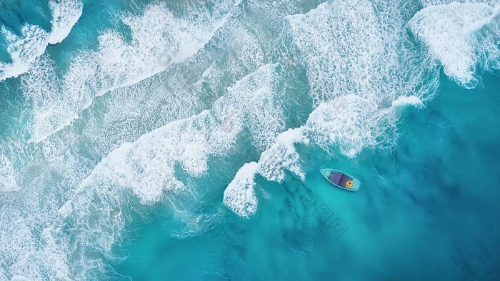 波浪和小船在海滩作为背景。美丽的自然背景在夏天时间从空气