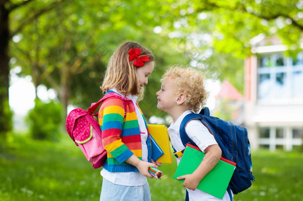 孩子上学去了。开学第一天，男孩和女孩拿着书本和铅笔。小学生们很兴奋回到学校。放假后开始上课。孩子们在学校院子里吃苹果