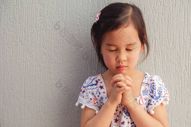 亚洲小女孩闭着眼睛祈祷