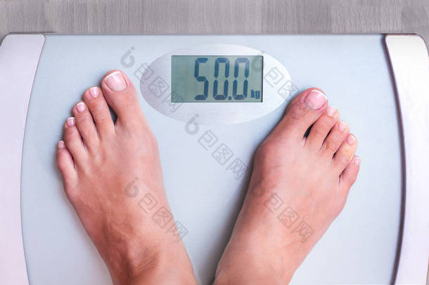 女人在权衡。一个女人的完美体重。体重表明一个女人重50公斤。重量控制
