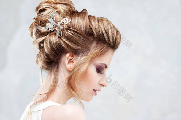 婚礼风格。美丽的年轻新娘与豪华婚礼发型