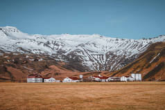 典型的冰岛风景与白色房子红色屋顶反对山在小村庄在南冰岛.