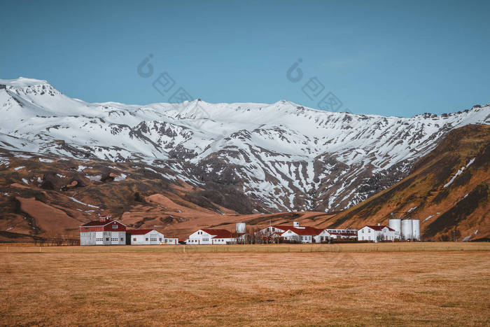 典型的冰岛风景与白色房子红色屋顶反对山在小村庄在南冰岛.