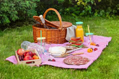 花园里绿草上有不同零食的野餐篮