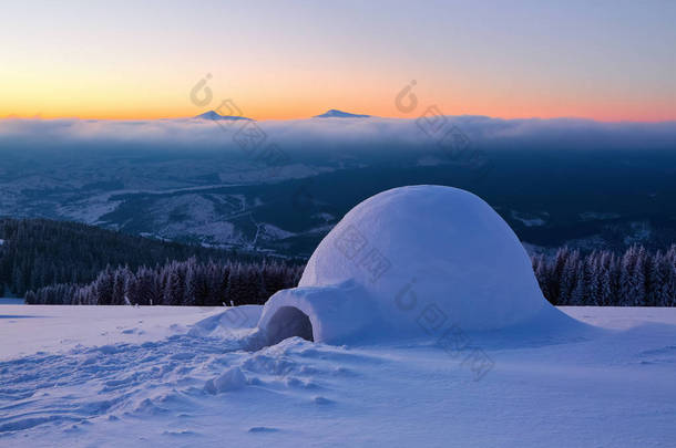 奇妙的巨大的白色雪小屋, 冰屋的孤立游客的房子站在远离人类眼睛的高山上。美丽的冬天风景.