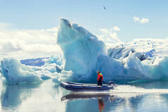 在 jokulsarlon 蓝色泻湖冰山之间的蔚蓝水域航行的机动船