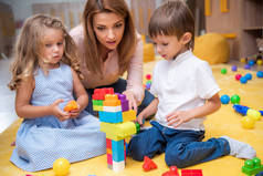 教育家和可爱的孩子在幼儿园里玩构造器