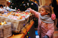 在假日市场上选择圣诞礼物的儿童女孩
