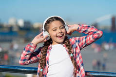 唱快乐。快乐的孩子戴着耳机。小乐迷。快乐的小女孩。小女孩在户外听音乐。好好享受吧