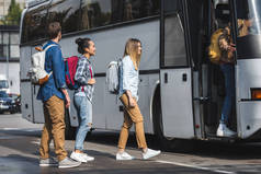 年轻的微笑游客与背包走进旅游巴士在城市街道 