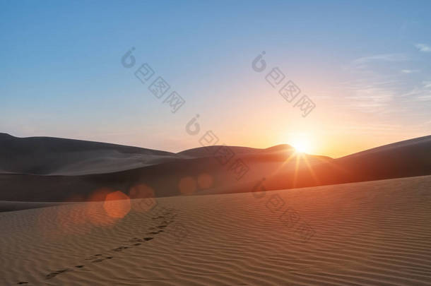 沙漠景观在日落, 美丽的落日和足迹在沙漠