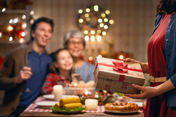 圣诞快乐！快乐的家庭正在家里吃晚餐。庆祝佳节及树旁聚居.