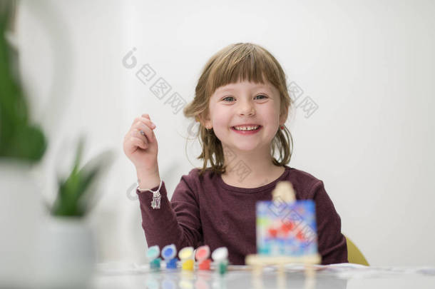快乐的小女孩在画布图像上绘画在家里
