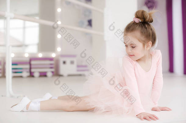 芭蕾工作室里的可爱小女孩在课堂上。穿着粉红色的短裙的小芭蕾舞演员女孩。可爱的儿童跳舞古典芭蕾在一个白色的工作室。孩子们跳舞。孩子们在<strong>表演</strong>。一个班里的年轻天才舞蹈家。上美术课的学龄前儿童
