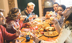 朋友团体品尝圣诞糖果食品和在家里享受喝香槟起泡酒的乐趣的前面的看法-寒假概念与人们享受时间一起吃饭-温暖的过滤器