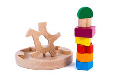 一个木制玩具儿童分拣器的照片，其木制细节呈几何形状（矩形、正方形、圆形、三角形），在白色孤立的背景中以不同的颜色出现