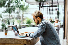 年轻有吸引力的商务人士在咖啡馆工作的笔记本电脑, 喝咖啡.