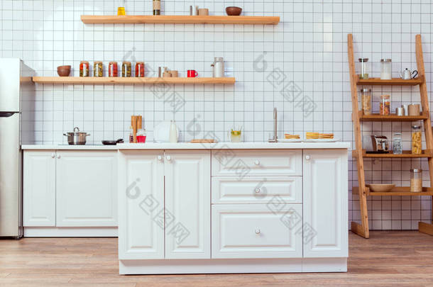 <strong>现代厨房设计</strong>，背景有白色家具和瓷砖