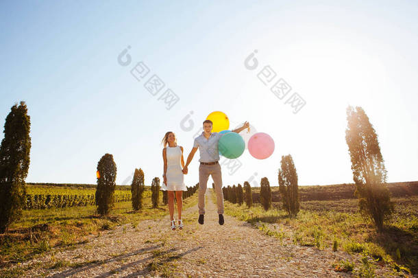 夏天, 情侣们在散步时笑着拥抱着, 拿着气球