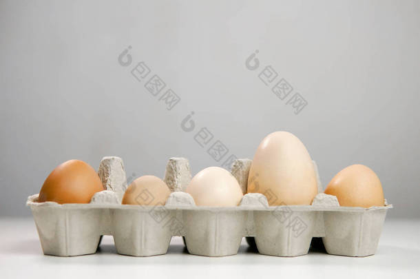 在浅色背景下, 鸡蛋盒中生鸡蛋的特写镜头