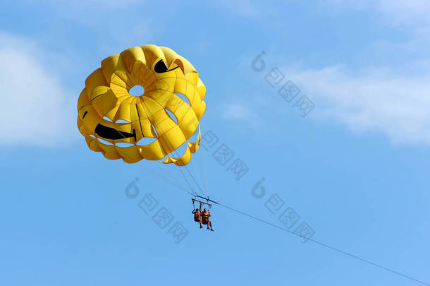 两个人在蓝天的背景下用降落伞滑翔。夏季背景.