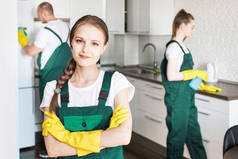 工作期间用专业设备提供清洗服务。专业厨房清洁，沙发干洗，窗户和地板清洗。穿着制服、工作服和橡胶手套的男女