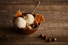 美味的冰淇淋，在木质表面的碗中加入华夫饼、勺子和薄荷糖