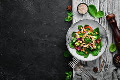 沙拉与蘑菇，菠菜，土耳其豌豆和洋葱在一个盘子在木制背景顶部视图。文本的可用空间。平铺