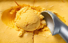 顶视图芒果风味冰淇淋球和勺子特写