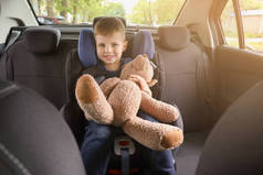 小男孩与玩具熊扣在汽车座椅