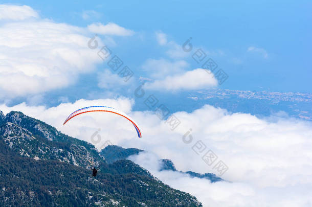 滑翔伞在山海的天空中飞行。土耳其塔塔塔利山的鸟瞰图。极限运动或旅行理念