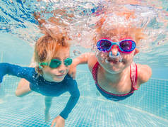 在暑假里玩泳池水下的玩耍的孩子