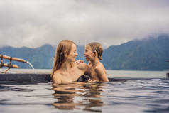 妈妈和儿子在巴厘岛温泉湖的背景旅行。儿童旅行概念