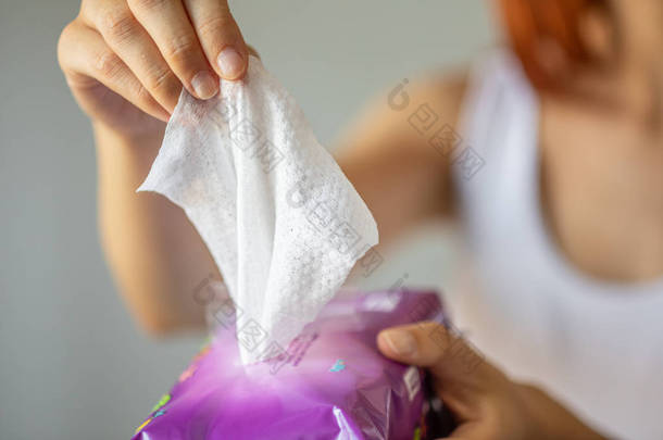 湿巾：妇女从包装中取一个湿巾进行清洁