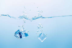 透明纯净水，蓝色背景上飞溅和冰块