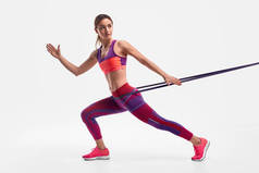 女运动员用阻力绳锻炼，看着远方
