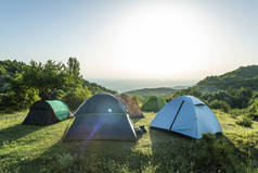 山上有许多帐篷。森林中的阳光早晨.