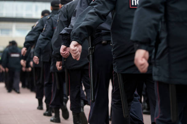 俄罗斯警察在街上巡逻，后视。警察拿着金属探测器，保安