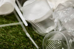 草地上皱褶的塑料杯和袋子的特写视图