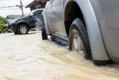 汽车在被洪水淹没的公路上行驶，那辆破车停在一辆小路上。