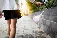 妇女用手在公共场所的地板上扔垃圾，女人们在路上乱扔垃圾，保护环境，污染环境，停止使用塑料袋