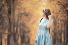 年轻女孩在秋天散步 