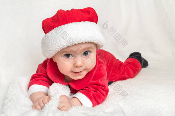 穿着圣诞老人<strong>服装</strong>的小<strong>宝宝</strong>躺在白色的毛毯上