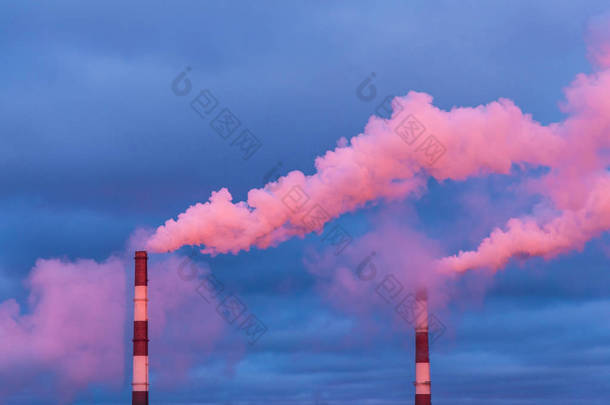 红光日出或日出时火力发电厂的蒸汽管. 多云的天空闪烁着红色、橙色、玫瑰红色、深红色、紫色、紫色和蓝色的光芒