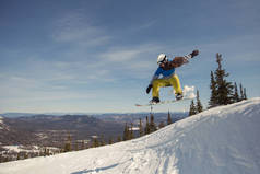 滑雪板上的女孩玩得很开心，在雪地里跳着。 冬季运动度假胜地