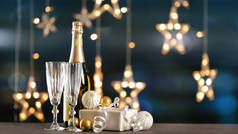 带着礼物和装饰的香槟放在桌子上，挡住模糊的灯光