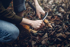 女旅行者用木棍的平面刀，手拿着特写镜头。 Bushcraft生存与侦察概念