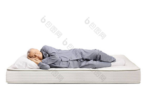 穿着睡衣睡在床垫上的老人 