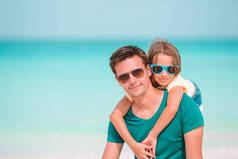 小女孩和快乐的爸爸在海滩度假期间玩得开心
